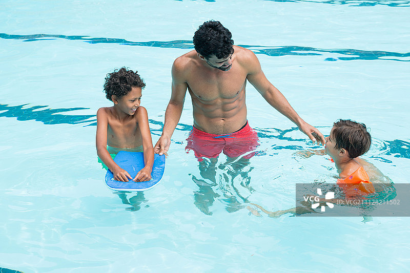 父亲与孩子们在休闲中心的游泳池里互动图片素材