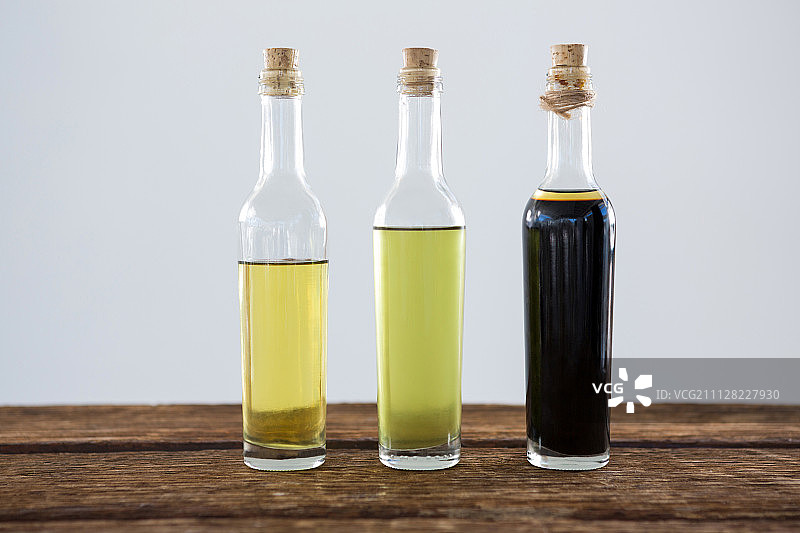 特写橄榄油和香醋的瓶子在桌子上图片素材