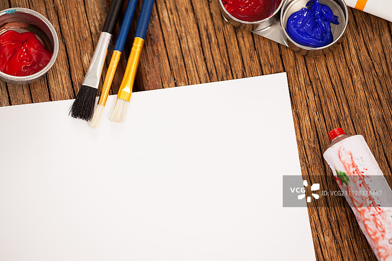 水彩颜料、画笔和白纸放在木桌上图片素材