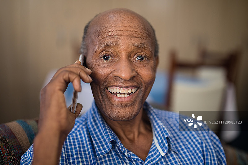 愉快的老人在疗养院用手机聊天的肖像图片素材