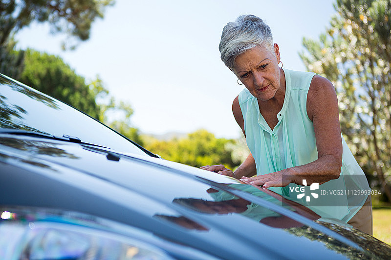 活跃的老年妇女检查她的车图片素材