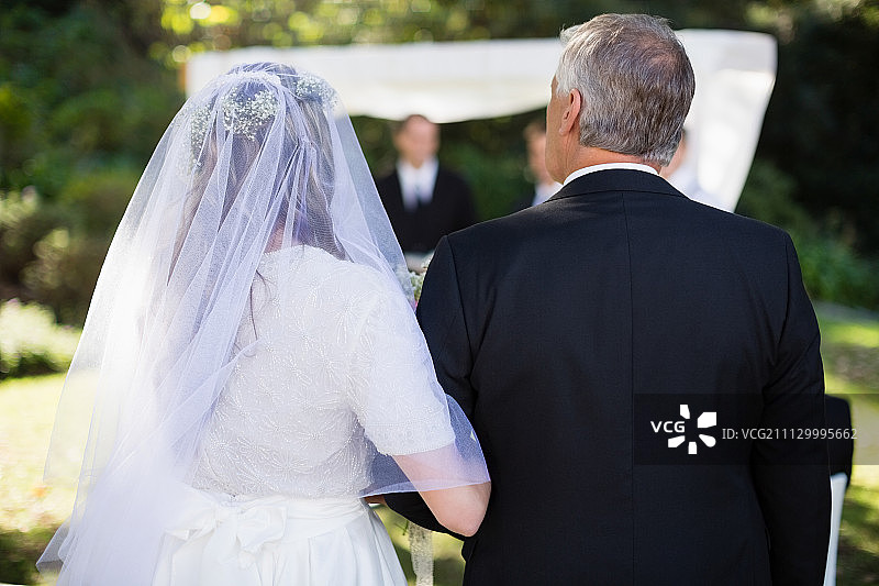 婚礼上，新娘和父亲站在公园里图片素材
