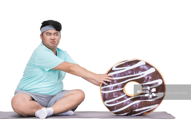 肥胖的青年男子拿着甜甜圈图片素材