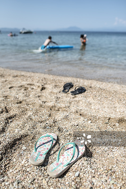 拖鞋在沙滩上的沙子里图片素材