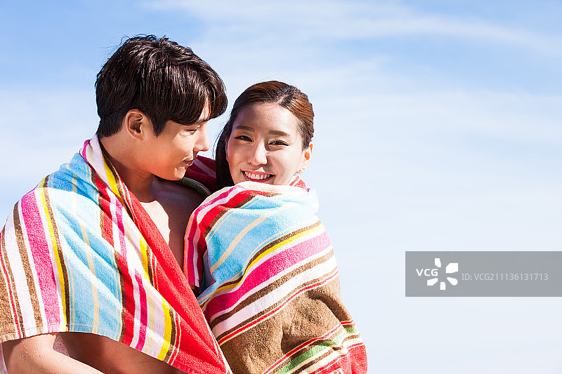 韩国夫妇沙滩毛巾和愉快的度假村游泳池图片素材