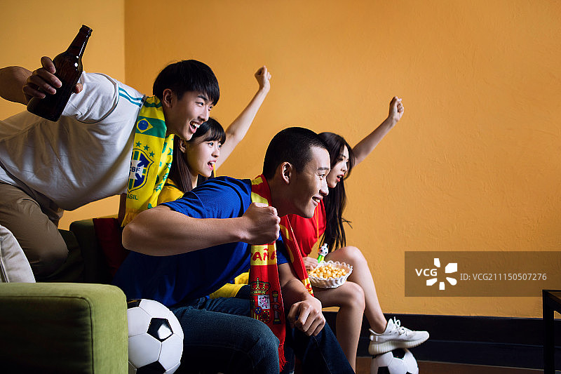 四个球迷在客厅聚会观看体育比赛图片素材