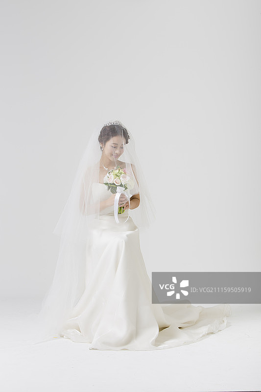 照片的女人与婚纱坐着拿花束图片素材