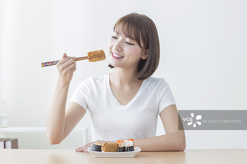 年轻女人吃寿司图片素材