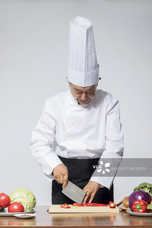 一个老年厨师正在切菜图片素材