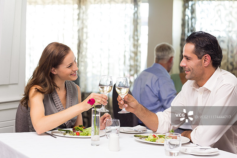 餐厅餐桌上互相敬酒的情侣图片素材