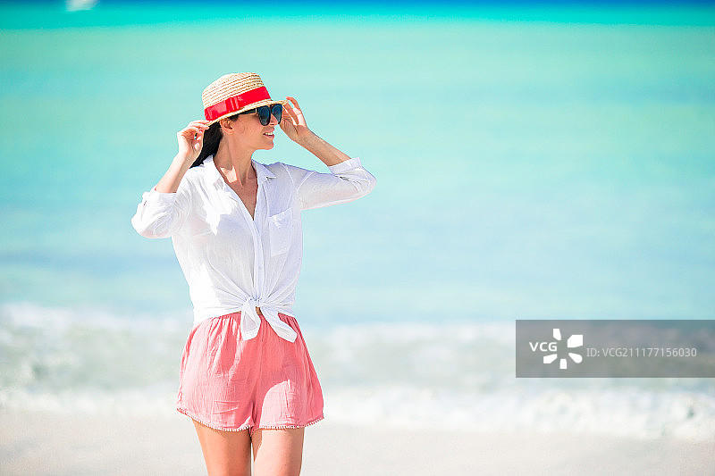 年轻美丽的女人有乐趣在热带海岸快乐的女孩背景蓝色的天空和图片素材