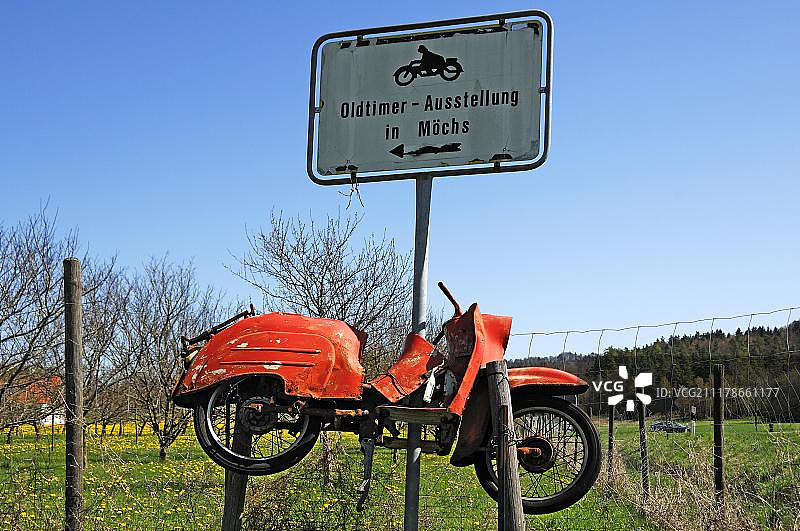 在德国巴伐利亚州上弗兰科尼亚的一个老爷车展览上，一个标志和一辆生锈的老摩托车图片素材