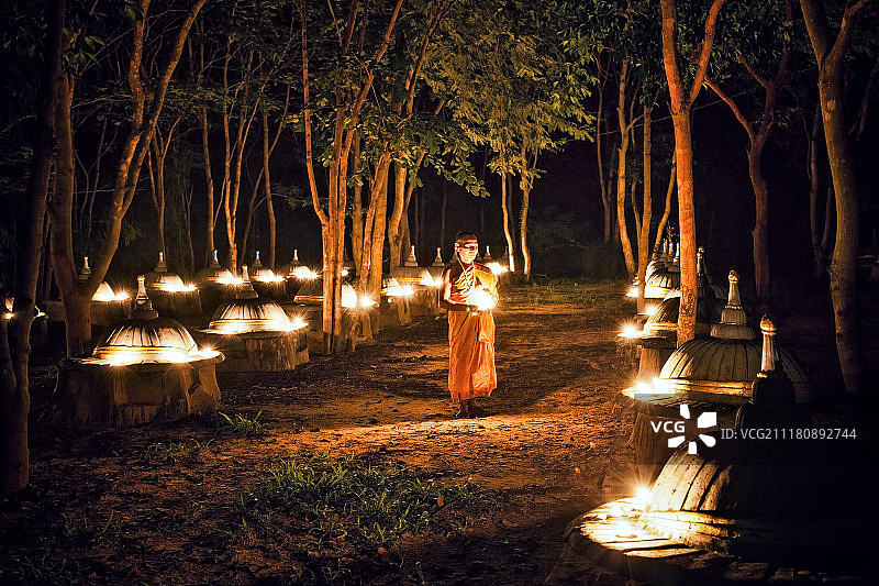 佛教僧侣在烛光下冥想图片素材