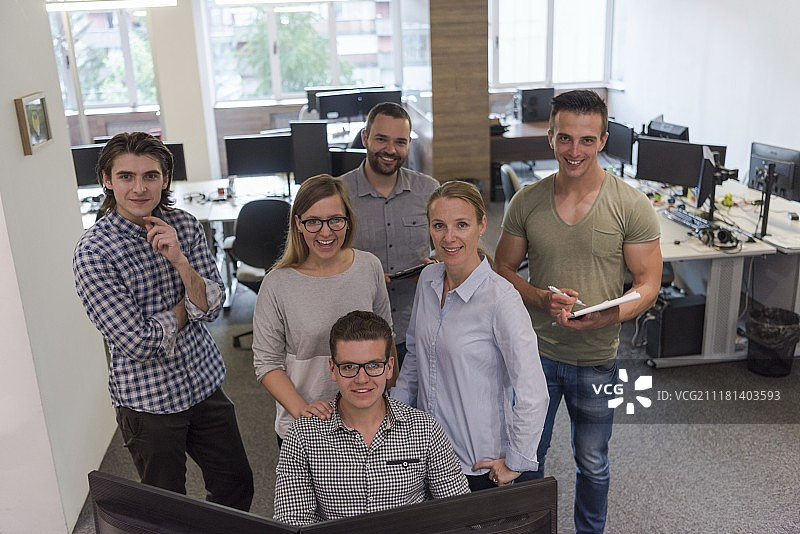 一群年轻的创业人士站在办公桌前完成日常工作图片素材