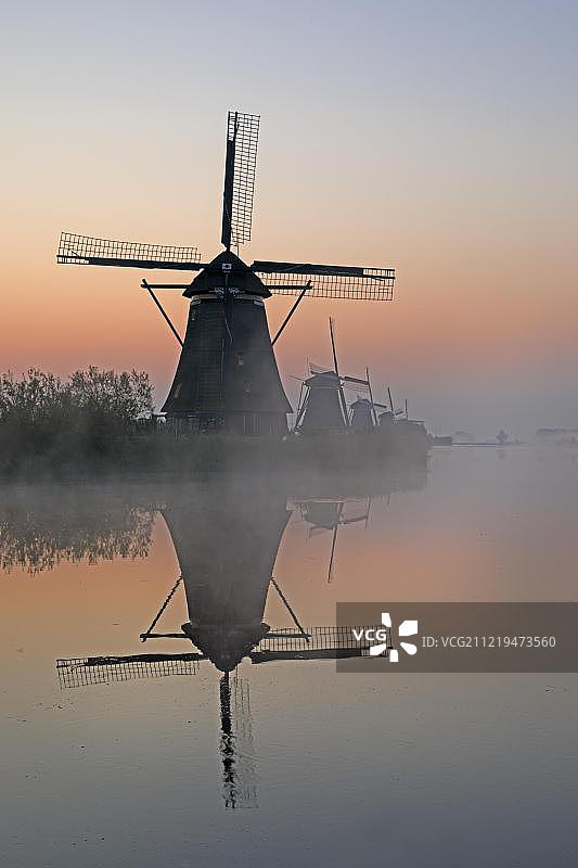 晨雾中的历史风车，联合国教科文组织世界遗产，荷兰南荷兰省Kinderdijk图片素材