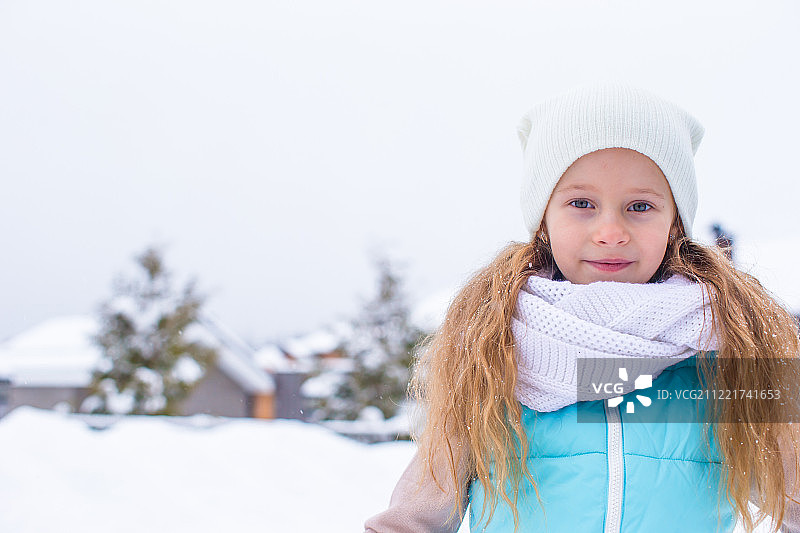 小可爱的女孩的肖像与美丽的绿色眼睛在雪阳光冬天的一天图片素材