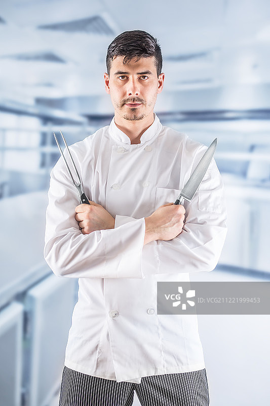 专业的餐厅厨房厨师，双手交叉站立，手持刀叉图片素材