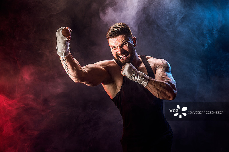 运动员泰拳拳击在黑色背景与烟雾图片素材