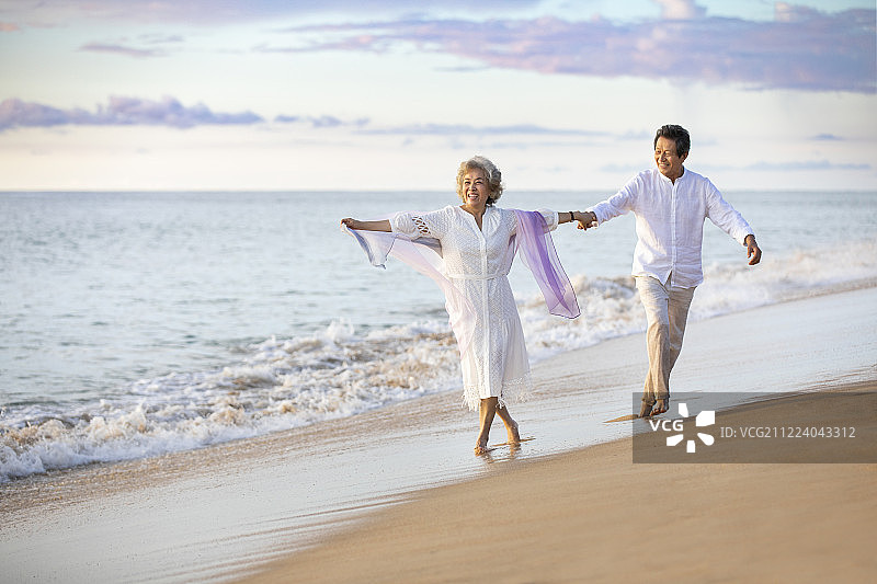 快乐的老年夫妇在沙滩跳舞图片素材