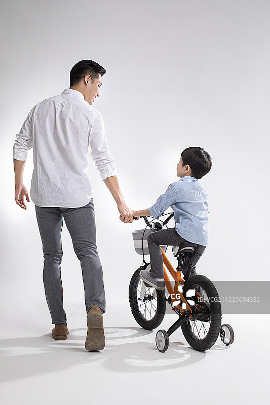 父亲教儿子骑自行车图片素材
