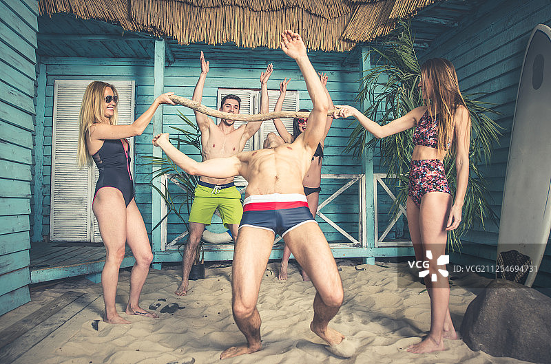 5个朋友在他们的夏日海滩别墅庆祝图片素材