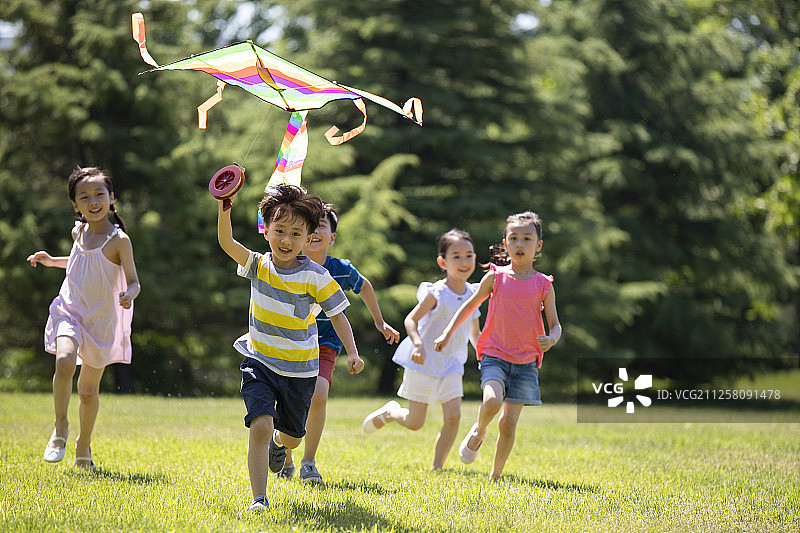 快乐的儿童在草地放风筝图片素材