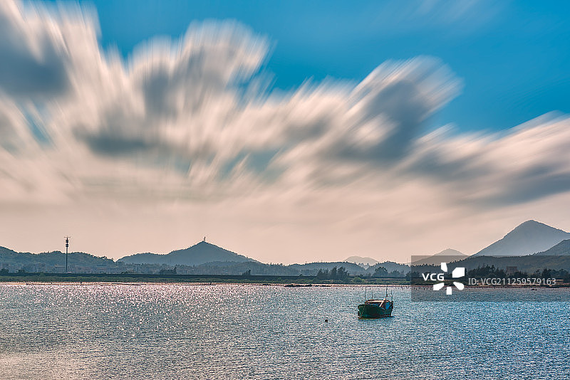 广东阳江海陵岛-逆光下停泊在港湾里的一艘渔船图片素材