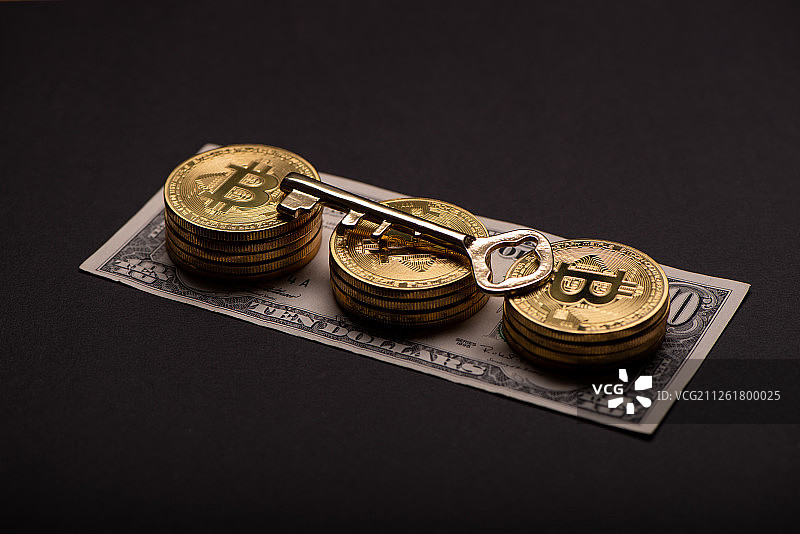 黑色背景上的金融比特币和复古钥匙图片素材