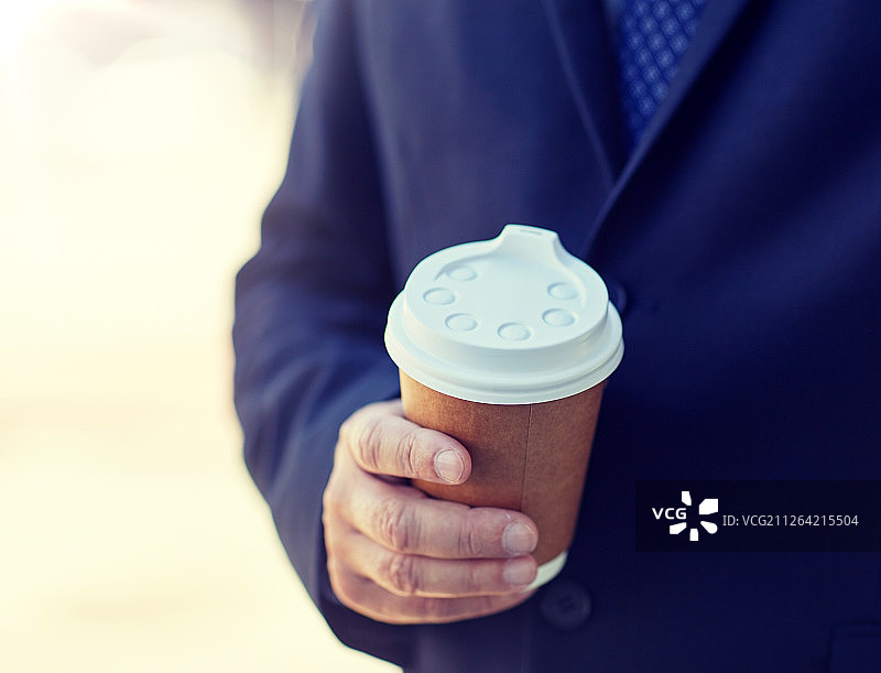 商务、热饮、休息、人和概念——高级商务人士在户外用一次性纸杯喝咖啡。资深商人在户外拿着咖啡杯图片素材
