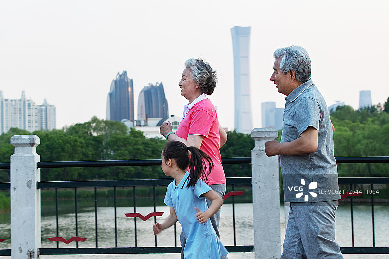 老年夫妇带着孙女在户外跑步图片素材