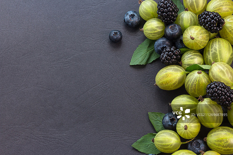 蓝莓，黑莓，醋栗和薄荷叶在黑色的背景图片素材