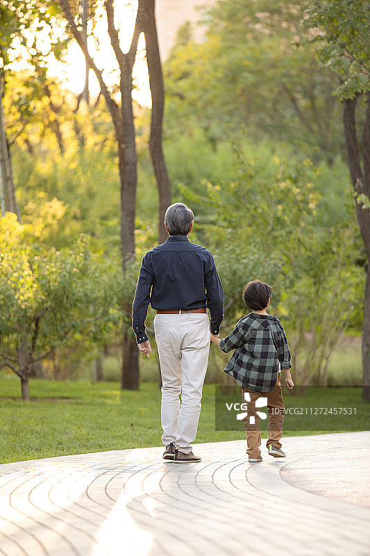 快乐的祖孙俩在公园一起散步图片素材