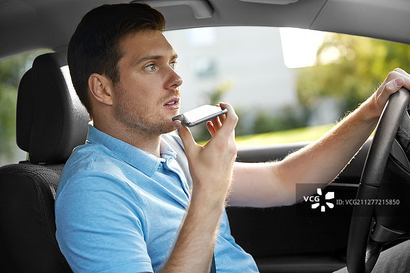 交通，车辆和人的概念-人或司机驾驶汽车和记录信息使用语音命令记录仪在智能手机上。男人开车并通过智能手机录音图片素材