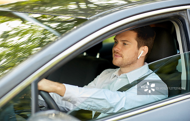 交通，车辆和人的概念-人或司机与无线耳机或免提设备驾驶汽车。带无线耳机驾驶汽车的人或司机图片素材