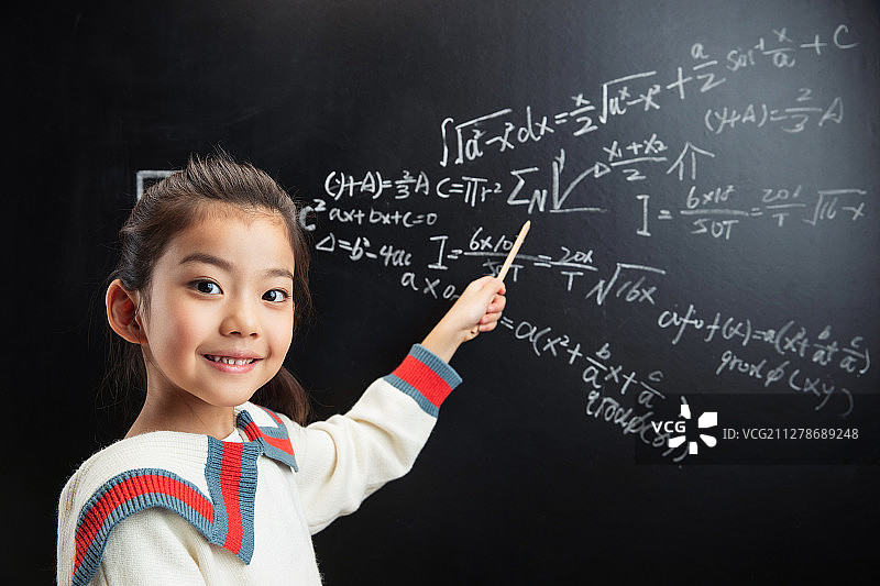 小女孩指着黑板上的数学题图片素材