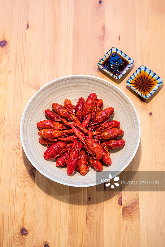 木桌上的一碗小龙虾与酱料正上方视角图片素材