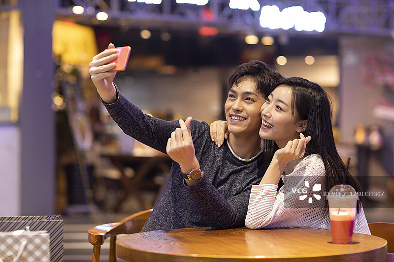 快乐的年轻情侣在商场自拍图片素材