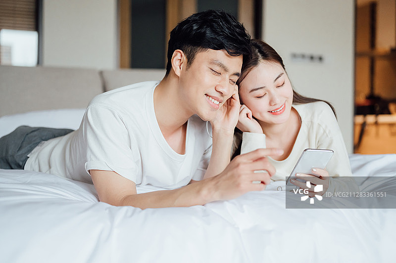 亚洲年轻情侣在家一起听歌图片素材