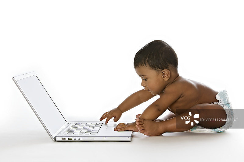男婴使用笔记本电脑的侧视图图片素材