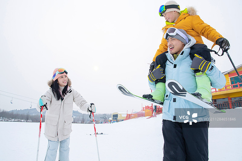 滑雪场内边滑雪边玩耍的三口之家图片素材