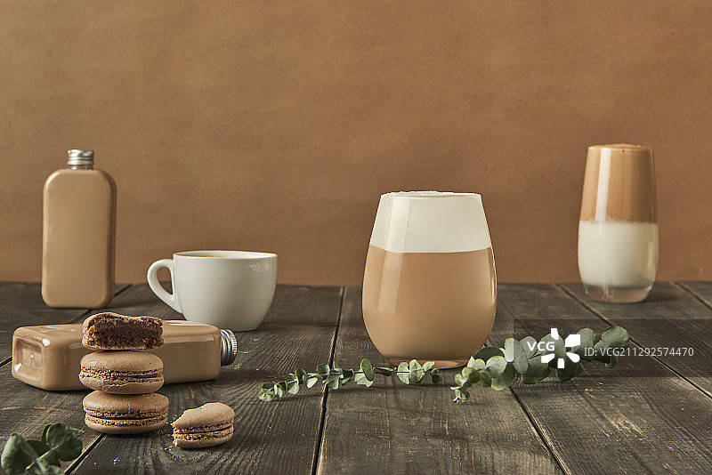 奶茶在奶瓶，马克杯和玻璃杯旁边的马卡龙图片素材