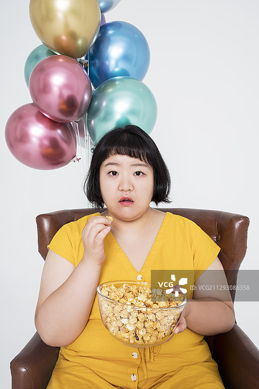 胖女人吃爆米花图片素材