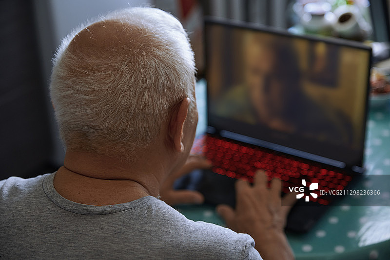 老人在家用笔记本电脑开视频会议图片素材