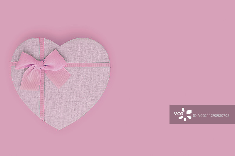 上图为粉色背景上的心形礼盒图片素材