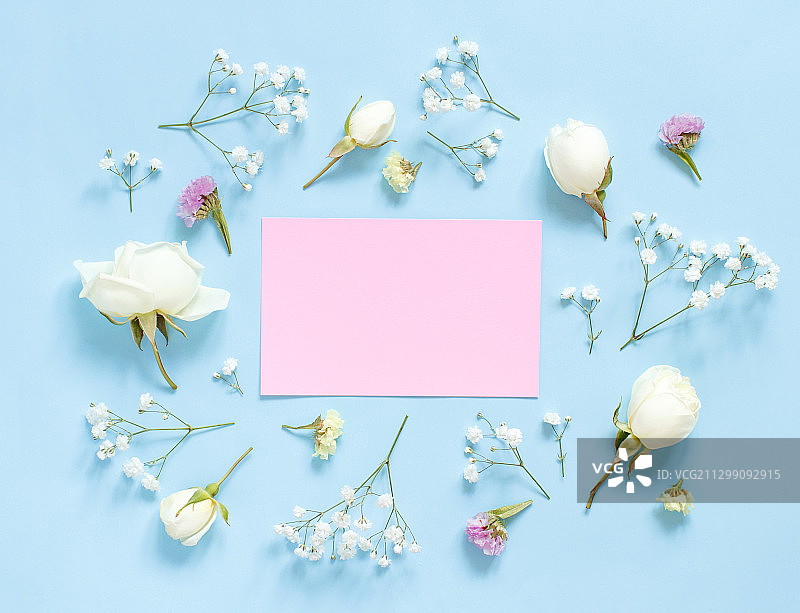 高角度的空白纸与花和装饰在蓝色的背景图片素材