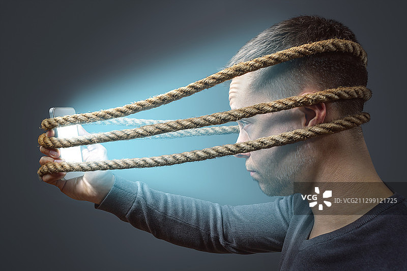 德国威登堡，一名被绳子绑在智能手机上的男子图片素材