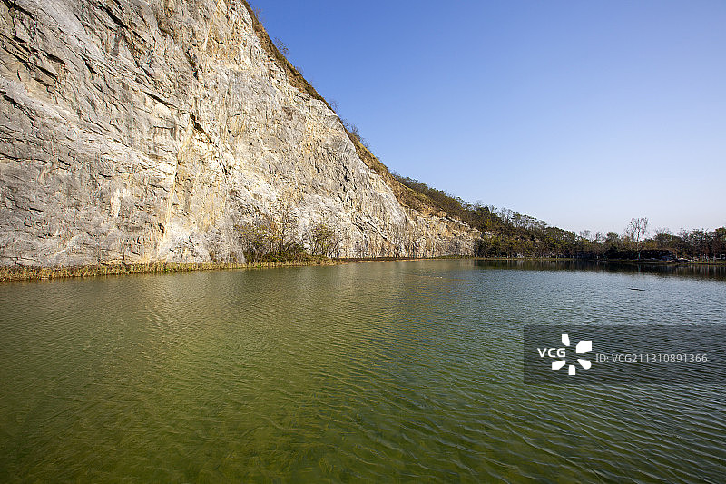 刀削般陡峭的石崖矗立在一池清水之上图片素材