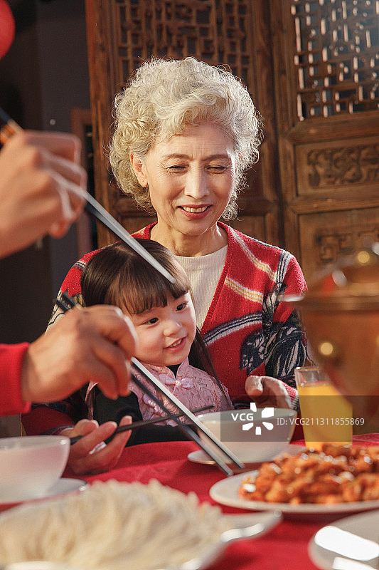 餐桌上抱着孙女的祖母图片素材