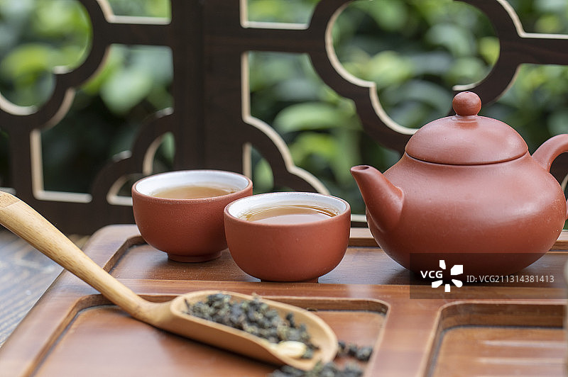 月光下窗花旁桌上的中国茶壶和茶杯富有禅意图片素材