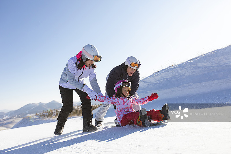 年轻家庭在滑雪场玩图片素材